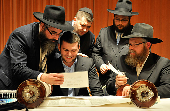 Die beiden Stifter der neuen Torahrolle David und Alexander Granovskiy (mit Kippa) mit beim Schreiben der letzten Buchstaben. (Foto: IsraelMagazin)